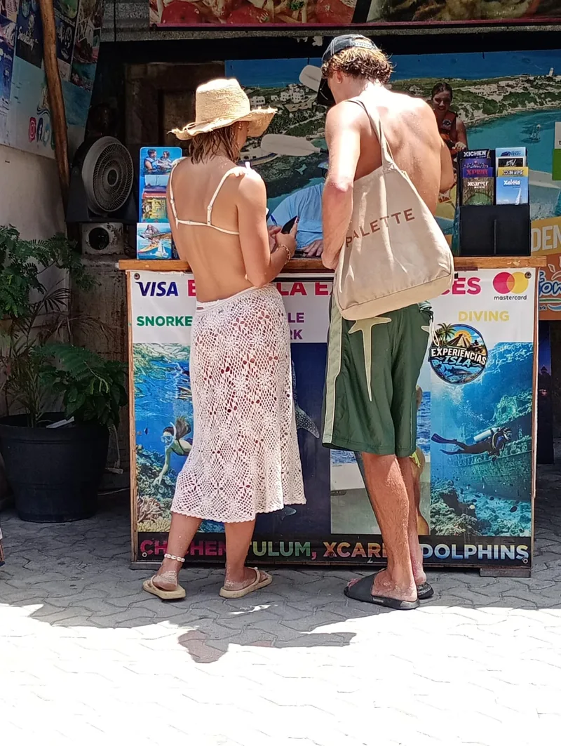 Turistas reservando en el mostrador de Experiencias Isla en el centro